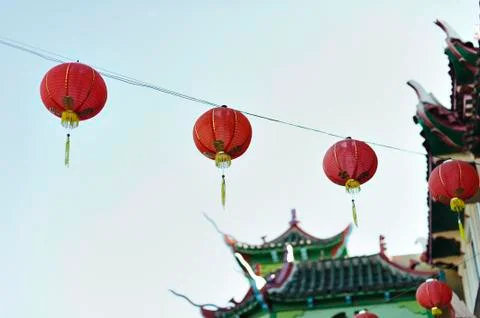 Stringed paper lanterns hang from oriental styled building Stock Photos