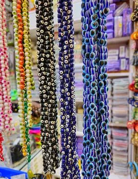 Strings of beads in various colors, including black, blue, and white, are p.. Stock-Fotos
