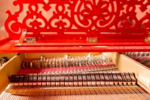 Strings inside a red grand piano. Piano playing, dampers, felt hammers, bronze Stock Photos