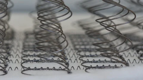 Strings of metal springs that will form the base of a sleeping mattress that Stock Footage 128724470