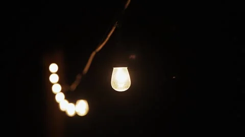 Strings of vintage edison light bulbs lighting up a dark night. Stock Footage 286179660