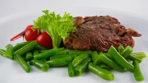 The strip Beef Steak, also called a New York strip with vegetables Stock Footage 79713832
