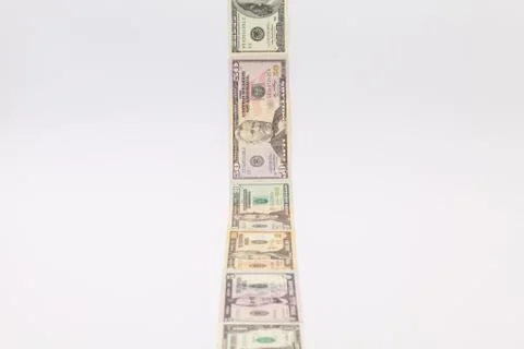 Strip of different us dollar banknotes on the white desk Photos