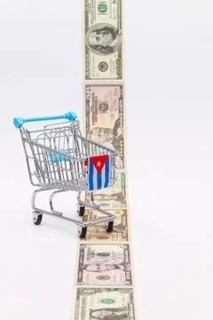 Strip of different us dollar banknotes and empty shopping trolley 库存照片