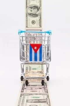 Strip of different us dollar banknotes and empty shopping trolley 库存照片