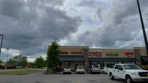 A strip mall with Metro PCS Cricket Mobile and restaurants with traffic and s Stock Footage 152431649