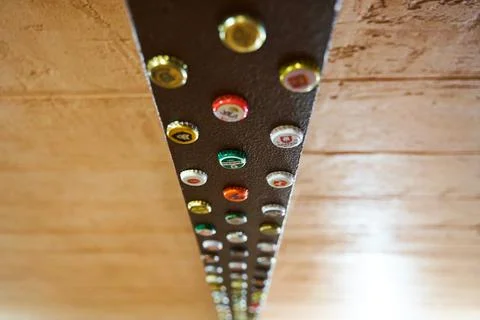 A strip of multi-colored beer caps, decor above the bar Stock Photos