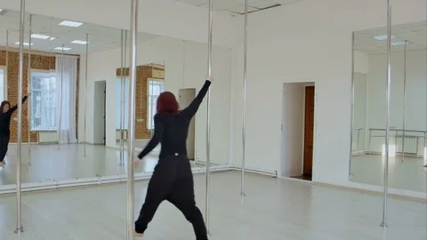 Strip plastic pole dancer exercising on pylon in studio Vídeos de archivo 76416292