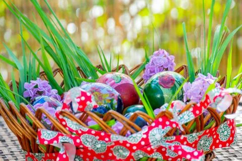 Striped basket full of Easter decoration standing on wooden table Stock Photos
