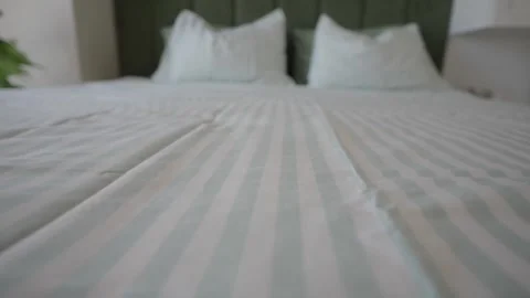 Striped bedding set on double bed in modern cozy bedroom interior with whit.. Stock Footage 331900393