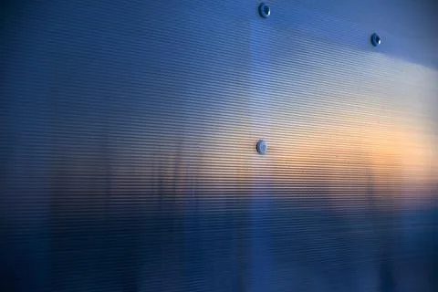 Striped blue polycarbonate in the rays of the evening sun 스톡 사진