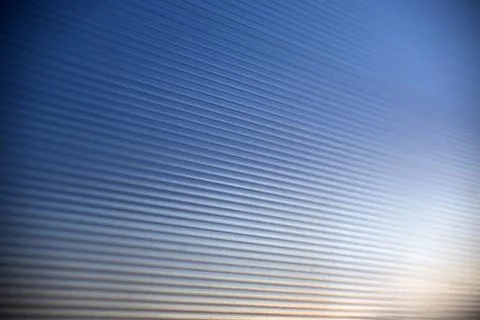 Striped blue polycarbonate in the rays of the evening sun Stock Photos