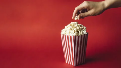 Striped box with popcorn with hand Stock Footage 134124322