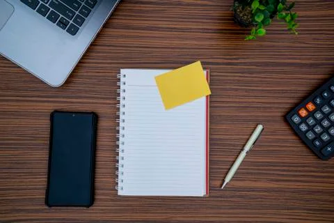Striped brown working table with note pad, mobile phone, pen, calculator a la Stock Photos