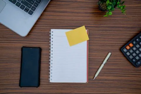 Striped brown working table with note pad, mobile phone, pen, calculator a la Stock Photos