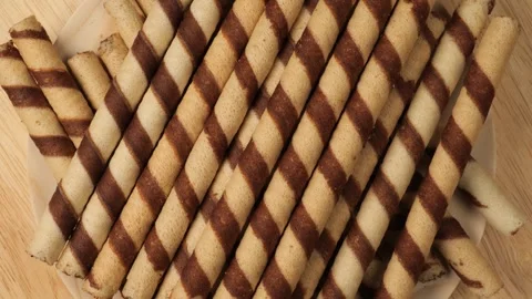 Striped chocolate wafer rolls rotating on a plate Stock Footage 344915226