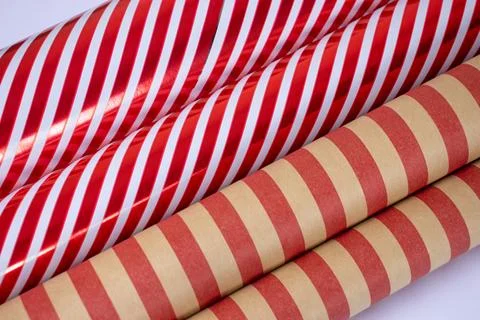 Striped gift wrapping paper for presents, red and white and craft paper rolls. Stock Photos