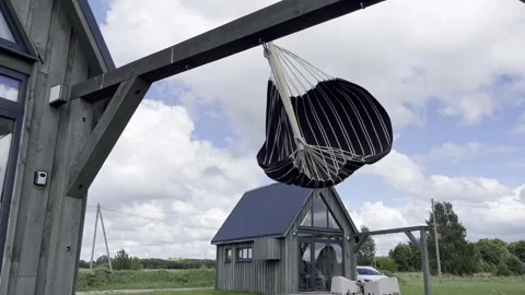 Striped hammock dangling in a strong wind. Camera moving down. Stock Footage 261809636