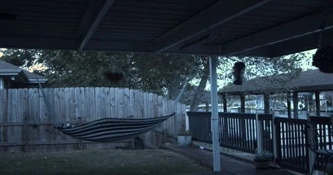 Striped Hammock Whipped by Strong Wind on Covered Backyard Patio 스톡 동영상 341596567