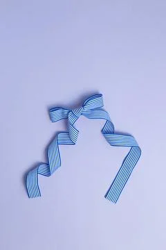 Striped pattern blue bow ribbon isolated on purple background Striped patt... Stock Photos