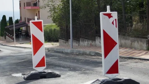 Striped red and white posts during road repairs, placed on the asphalt Stock Footage 315176835
