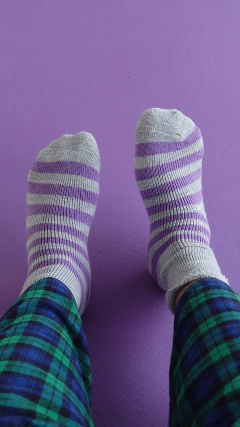 Striped socks on purple surface during cozy indoor time Stock Footage 309976324