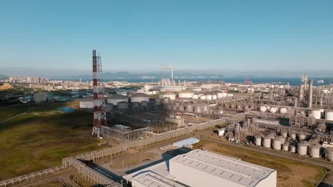 Striped stack and processing plant beside storage tanks at Daya Bay Stock Footage 347457655