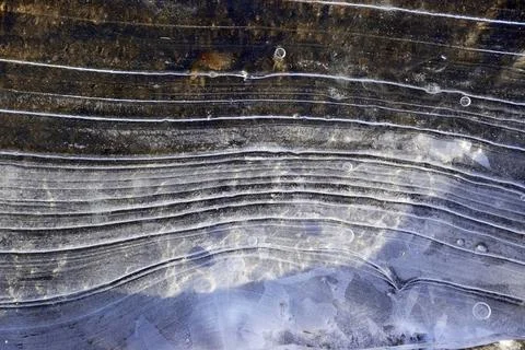 Striped texture of thin young ice Stock Photos