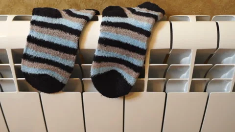 Striped warm socks drying on heating radiator Stock Footage 109272663