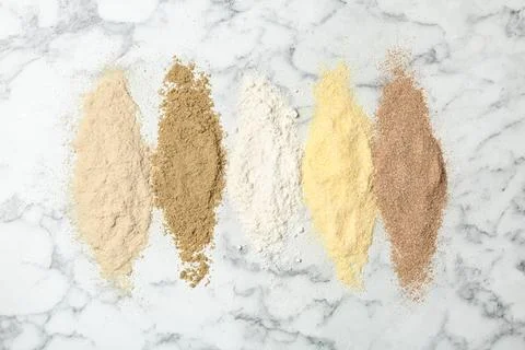 Stripes of different flour types on marble background, top view Stock Photos