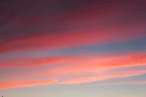 Stripes of red clouds at sunset. Stock Photos