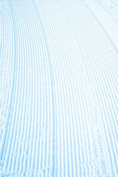 Stripes on snow surface profiled for future ski trace. Stock-Fotos