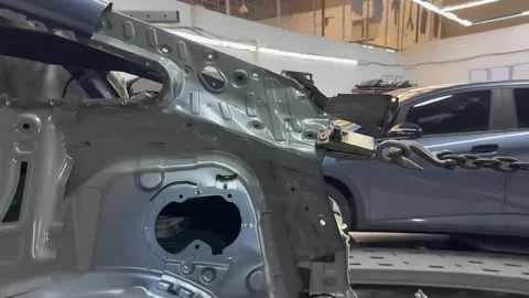 Stripped Car Body Shell With Chain Clamp in Collision Repair Shop Stock Footage 348691464