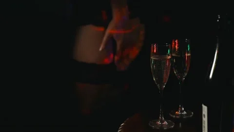 Stripper dances in front of glasses with champagne in night club. Stock Footage 204798762