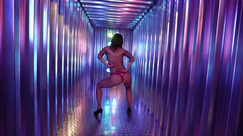 Stripper dancing in a large mesh suit and a thong, is in the studio in neon Video stock 153597804