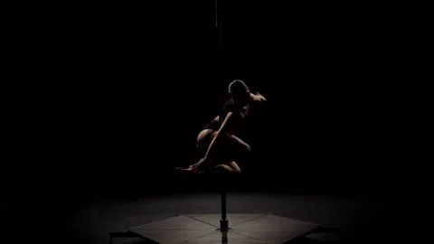 Stripper doing pole dance . Black background. Slow motion. Silhouette Stock Footage 94452652