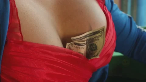 Stripper tugging her breasts on a squeezed banknote Stockbeeldmateriaal 172240576