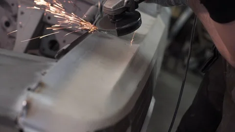 Stripping the paint of the front wing of the car in the workshop Stock Footage 129285489