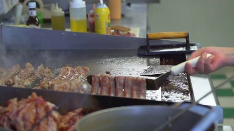 Strips of bacon being moved around on stove Stock Footage 73883018