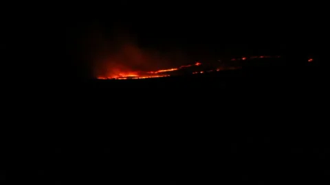 Strips of fire in distance in darkness Stock Footage 115951535