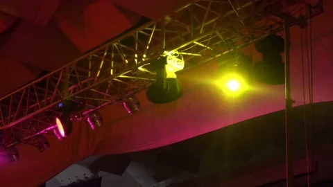 Strobe lights emitting different color beams hanging under the ceiling Видео 80481341