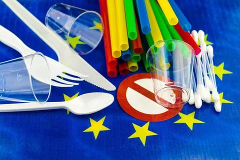 Strohhalme, Becher, Besteck und Wattestaebchen aus Plastik auf Europaflagg... Stock Photos