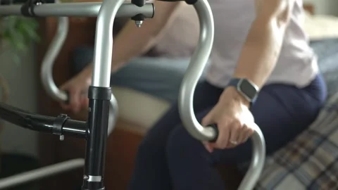 A stroke patient's hands grip a walker and rise from bed. 스톡 동영상 340951593