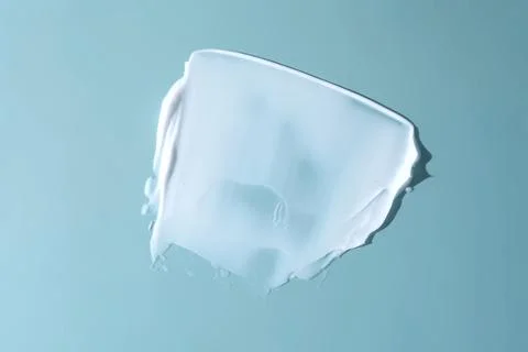 Stroke of white cream on a blue background. Stock Photos