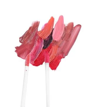 Strokes of different lip glosses and applicators isolated on white, top view Stock Photos