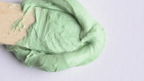 Stroking green clay mask over white surface. Texture of green clay mask. Sw.. Stock Footage 271129545