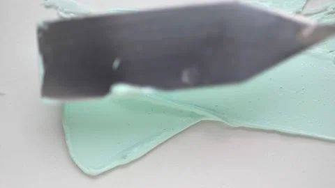 Stroking green handmade clay mask over white surface Stock Footage 170358260