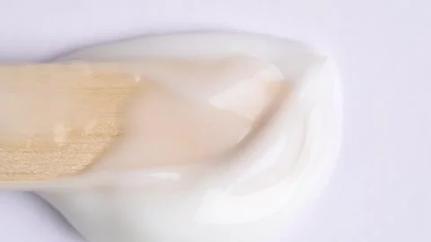 Stroking white cream over white surface, rotating. Swatch face cream. Hydra.. Stock Footage 268846461