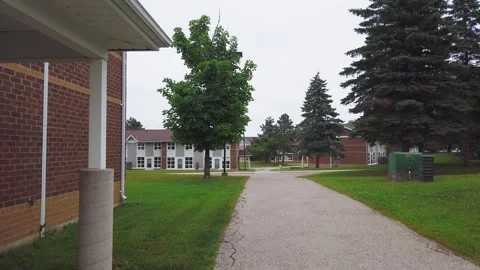 A stroll through the campus past brown brick cottages and tree-lined lawns. Stock Footage 314331137