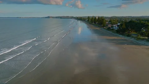 Strollers out enjoying Orewa beach at dusk, Auckland, New Zealand Video stock 171356342